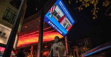 People walk past a big screen showing U.S. President Joe Biden and Chinese President Xi Jinping attending their virtual summit, during the evening news program, in Beijing, China, Nov. 16, 2021. (EPA Photo)