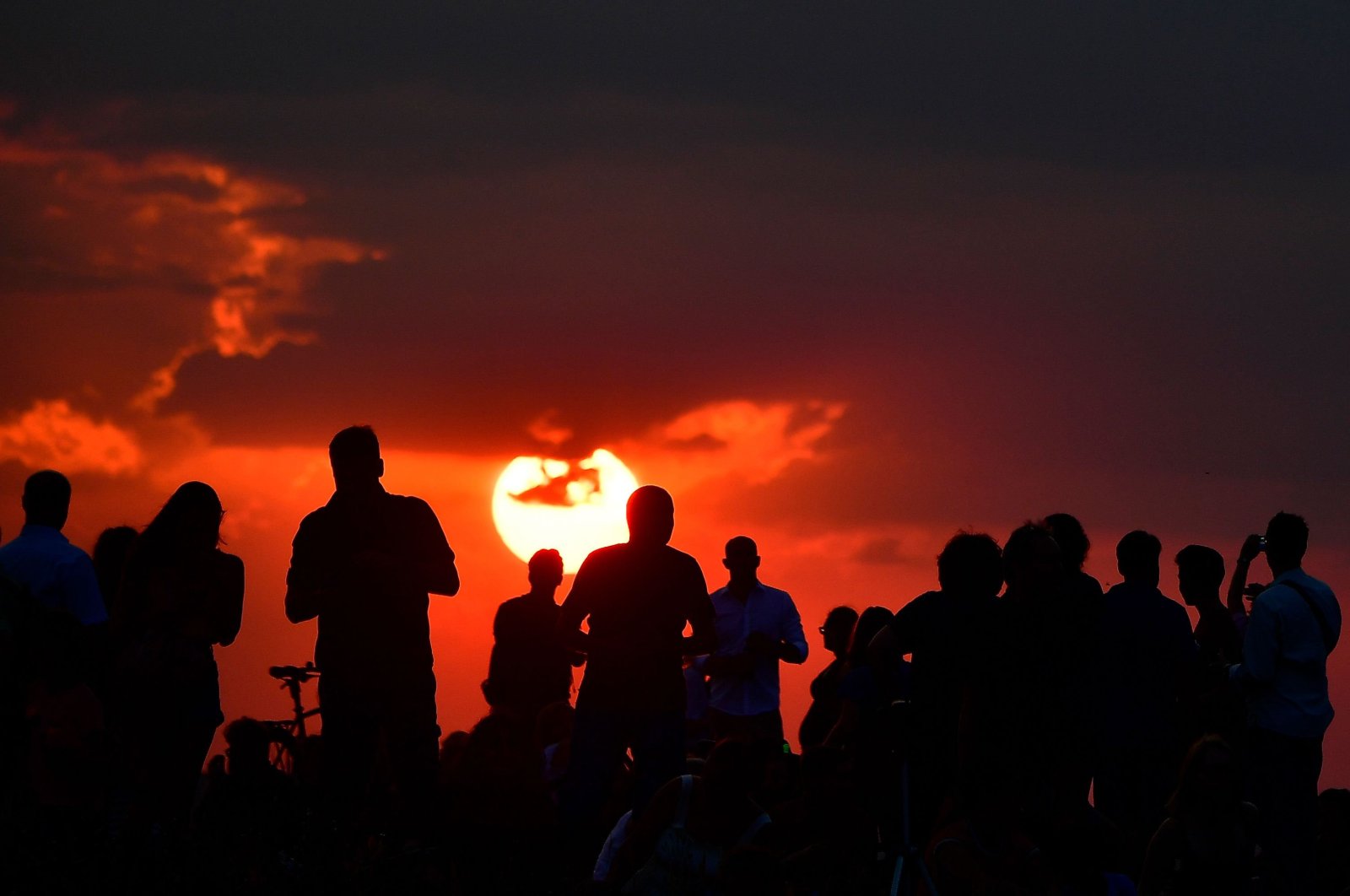 People gather as they wait for the sun to go down and the appearance of the "Blood moon" in Berlin, Germany, on July 27, 2018. (AFP PHOTO/Tobias SCHWARZ)