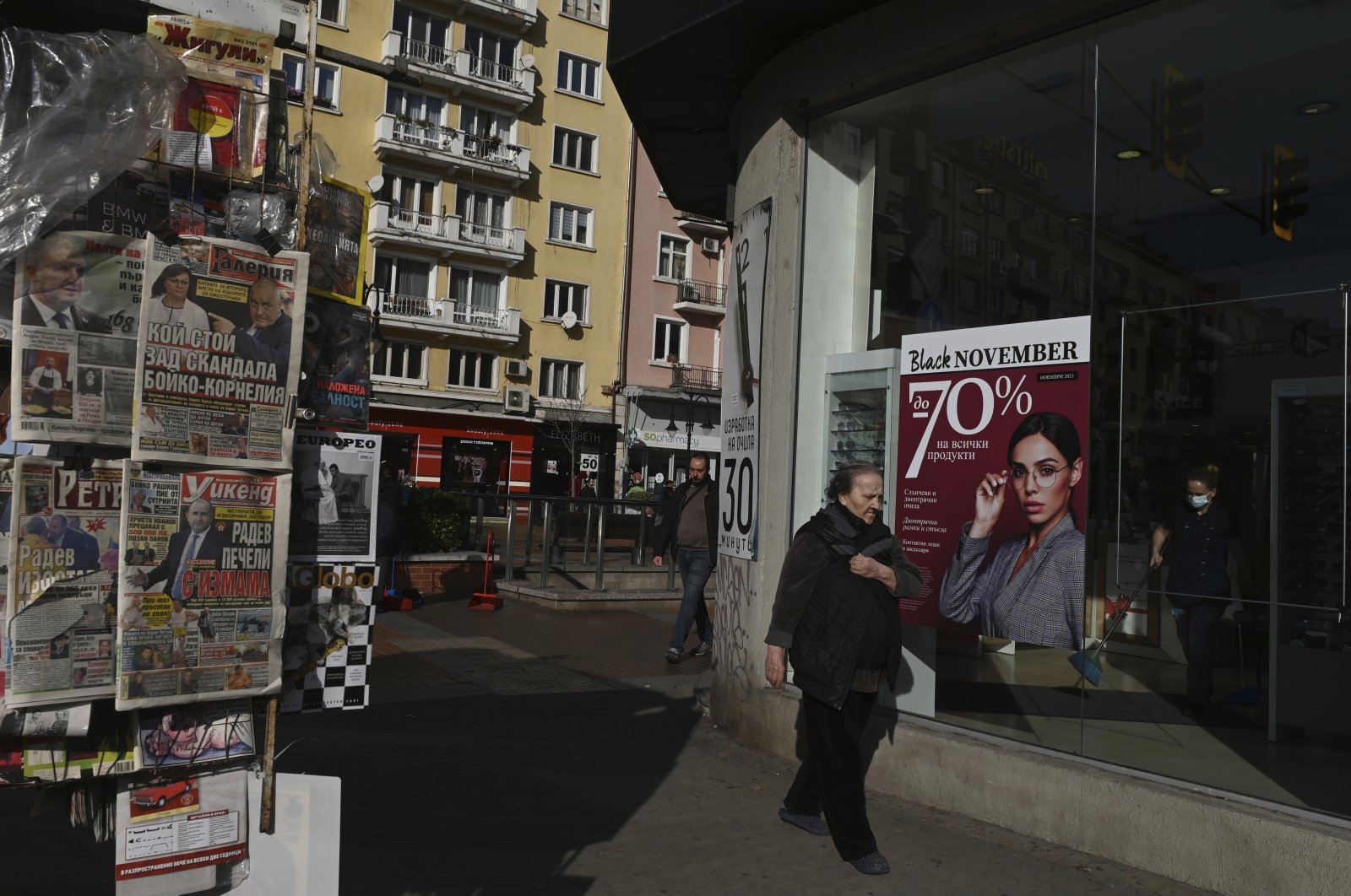 People walk by a kiosk selling newspapers in Sofia, Bulgaria, Nov. 13, 2021.  (AP Photo)