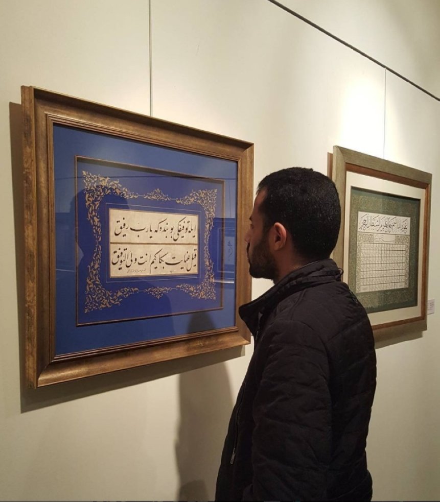 Calligrapher Zaki al-Hashimi examines a work. (Instagram / Zaki al-Hashimi) 