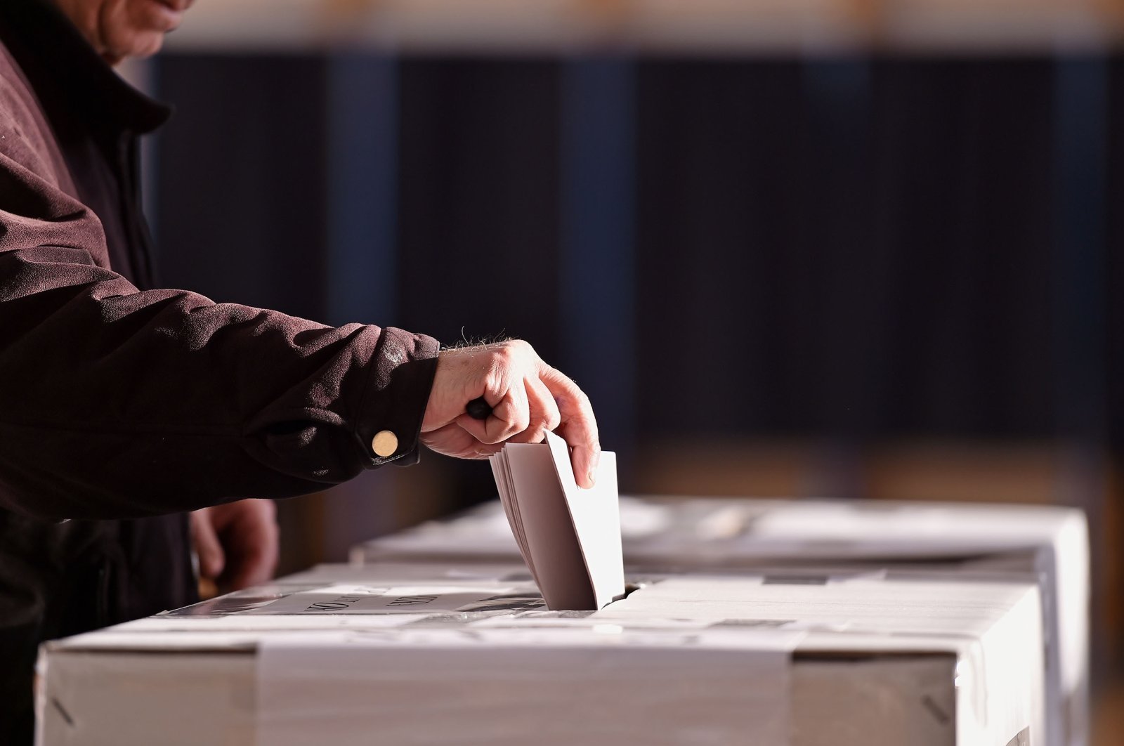 A person casting a vote into a ballot box during elections. (Shutterstock Photo)