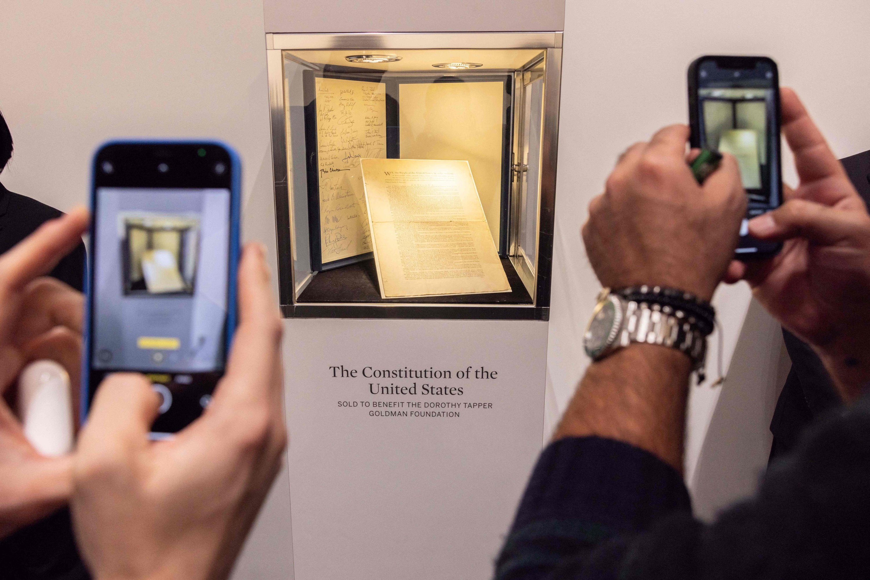 People take pictures of the first printing of the United States Constitution during an auction at Sotheby's auction house in New York, U.S., Nov. 18, 2021. (AFP Photo)