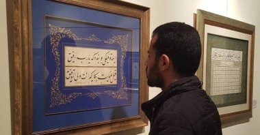 Calligrapher Zaki al-Hashimi examines a work. (Instagram / Zaki al-Hashimi) 