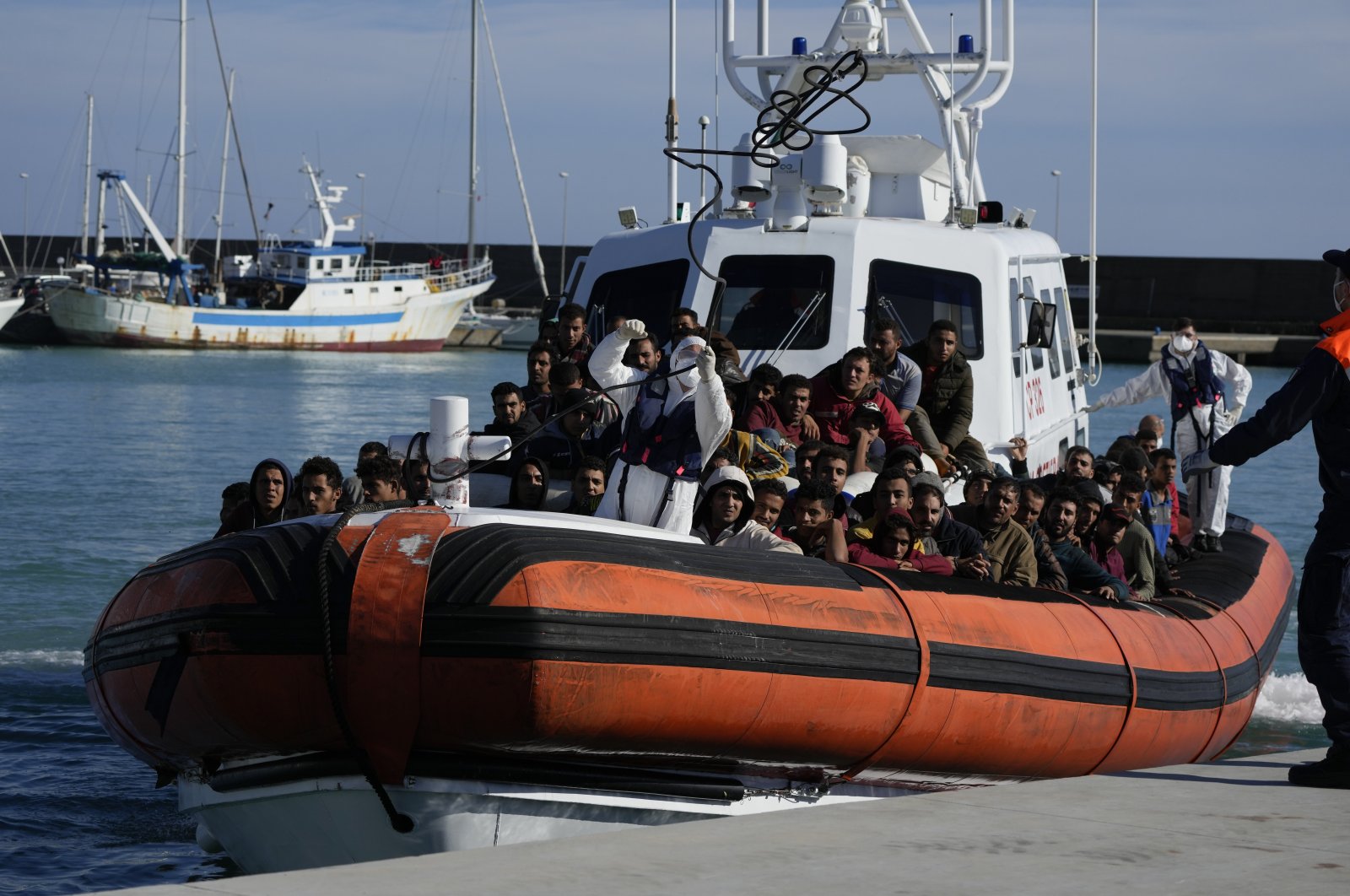 Migrants and refugees enter in the port of Roccella Jonica, Calabria region, southern Italy, Sunday, Nov. 14, 2021. The Italian Coast Guard rescued  over 250 young men and boys, mostly from Egypt, Sunday morning off the cost Calabria. (AP Photo/Alessandra Tarantino)