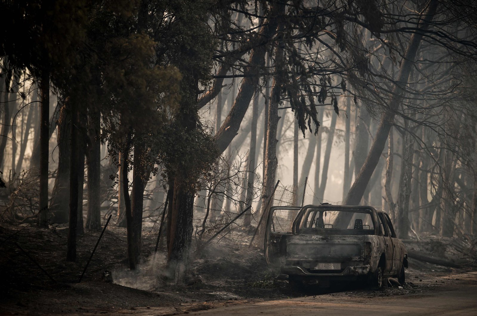 A burned car is seen in a forest in Varybombi, a suburb north of Athens, as fires broke out at the foot of Mount Parnes, 30 kilometers north of Athens, Greece, Aug. 4, 2021. (AFP File Photo)