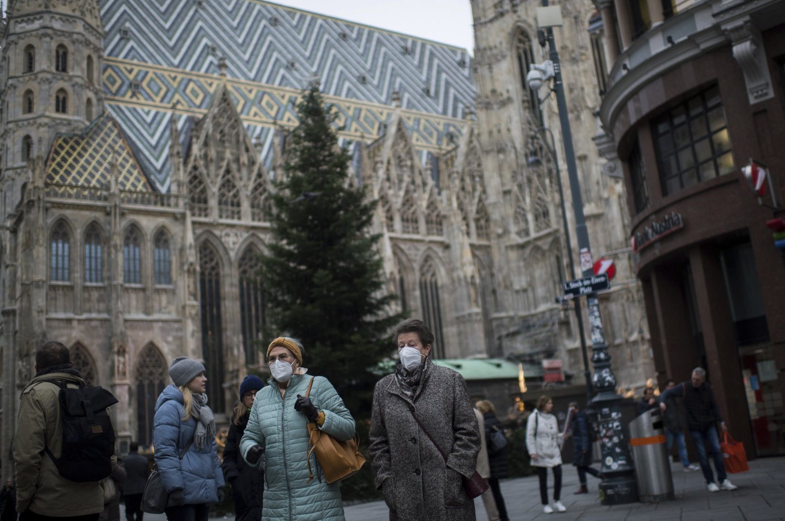 People wearing face mask to protect against the coronavirus as they walk in front of St. Stephen&#039;s Cathedral in Vienna, Austria, Nov. 17, 2021. (AP Photo)