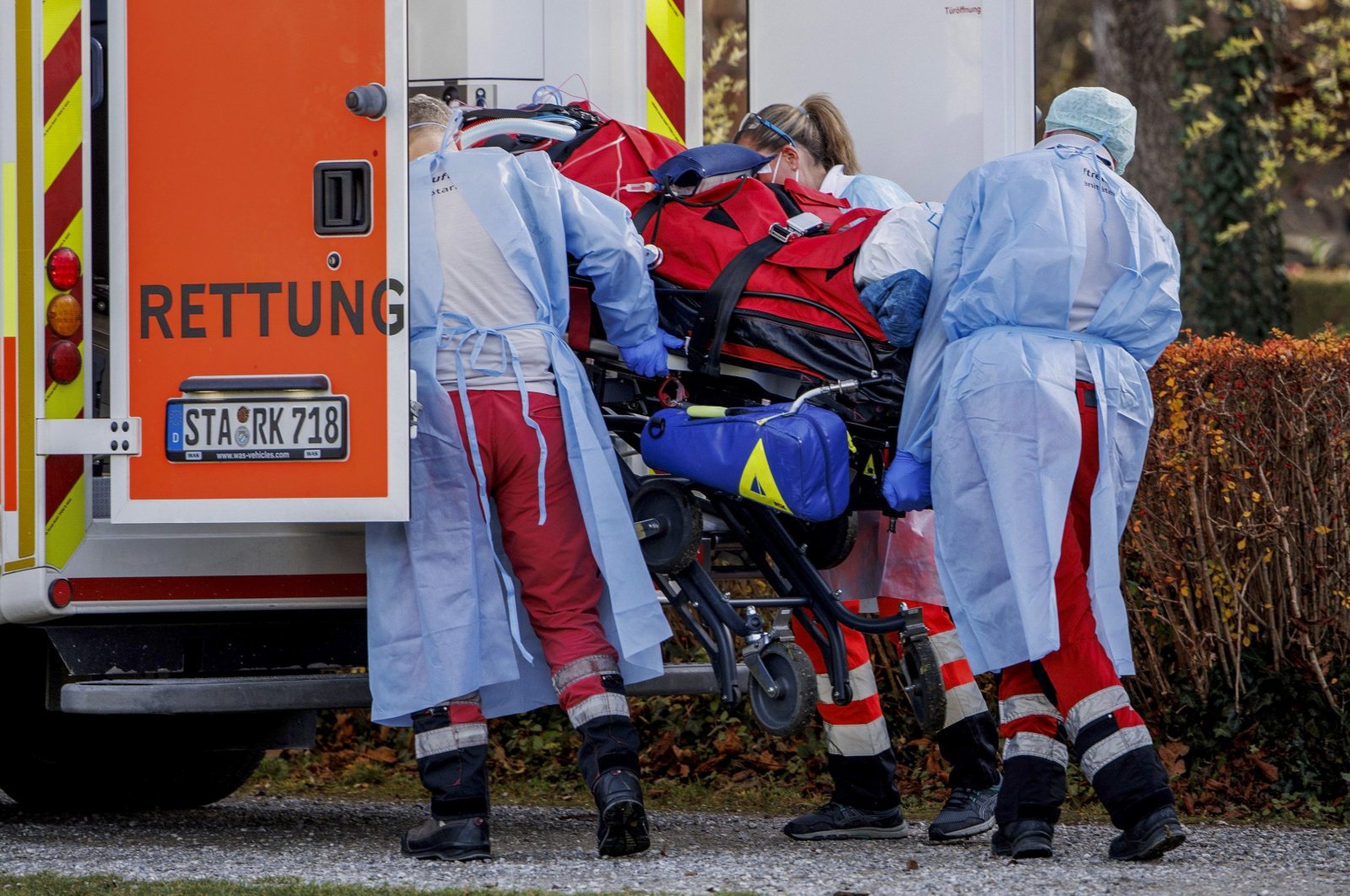 Rescue workers load a COVID-19 intensive care patient from an air rescue helicopter onto an ambulance vehicle at a sports field in Herrsching, Germany, Nov. 19, 2021. (dpa via AP)