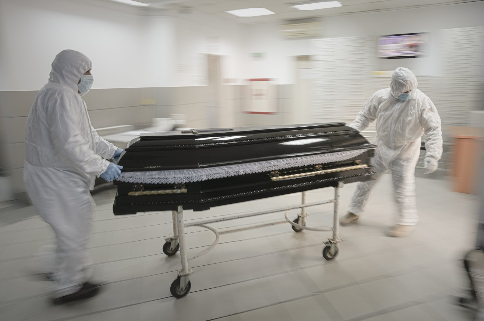 Funeral house employees drag a coffin on a trolley as they arrive at the University Emergency Hospital morgue to take a COVID-19 victim for burial, in Bucharest, Romania, Nov. 8, 2021. (AP Photo)