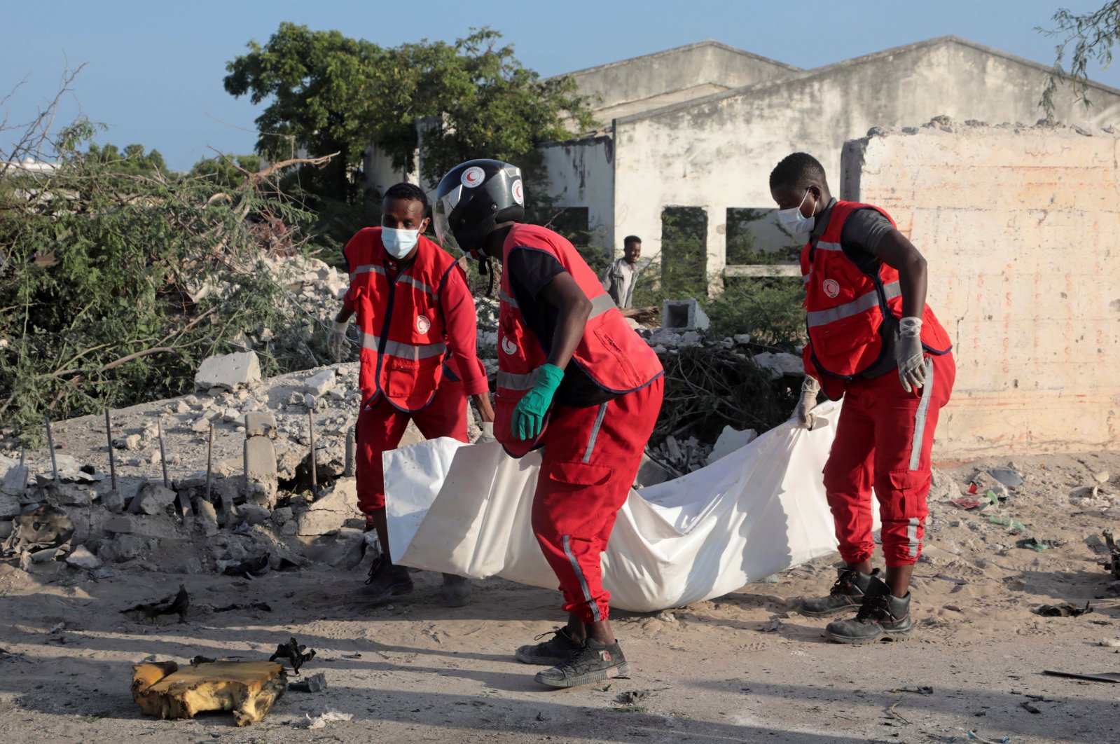 Red Crescent workers remove the body of a man killed at the scene of a suicide explosion targeting the African Union Mission in Somalia (AMISOM) convoy in Mogadishu, Somalia, Nov. 11, 2021. (Reuters Photo)