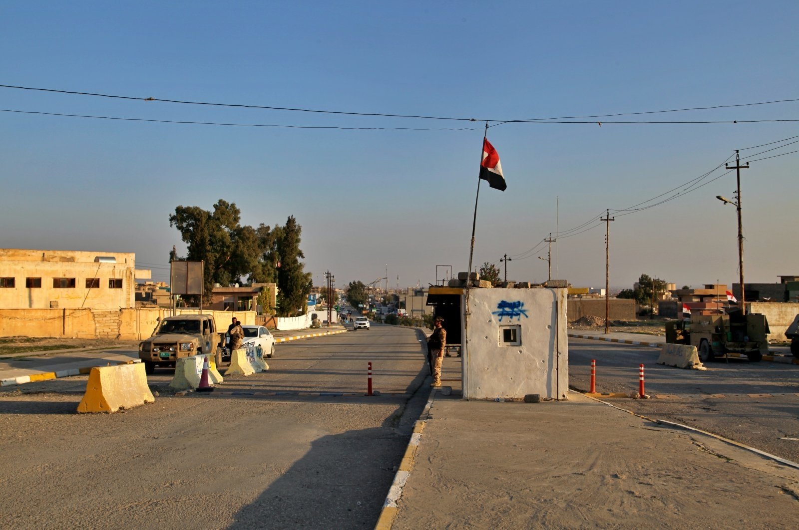 Iraqi soldiers stand guard under a national flag at a checkpoint in the city of Sinjar, Iraq. Dec. 4, 2020. (AP File Photo)
