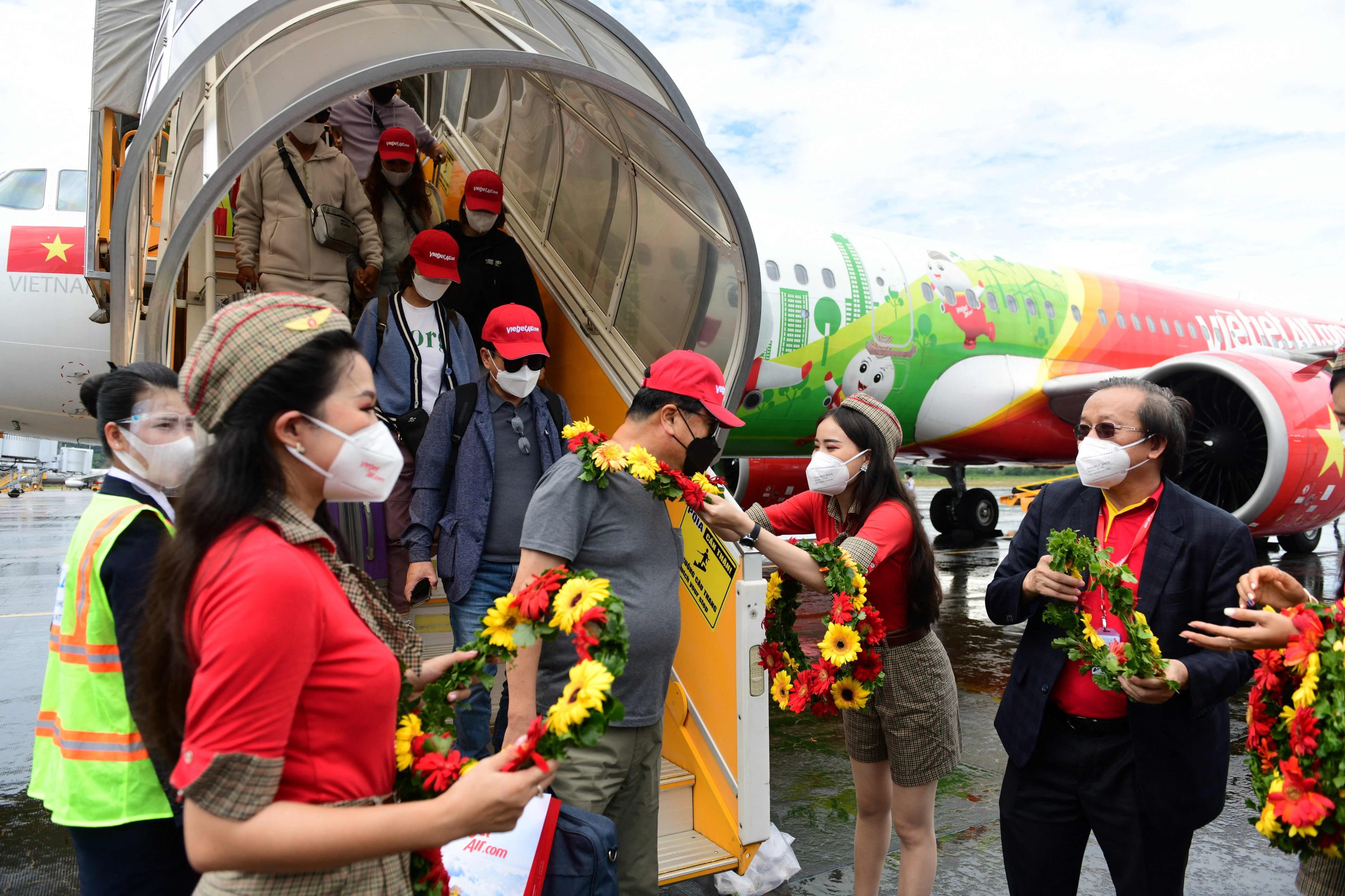 Wisatawan Korea Selatan yang tiba menerima karangan bunga setelah mendarat di pulau Phu Quoc, Vietnam, 20 November 2020. (AFP Photo)