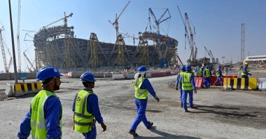 Construction workers walking next to Lusail, one of World Cup stadiums, in Doha, Qatar, Dec. 20, 2019. (AFP PHOTO) 