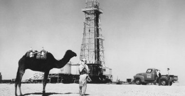 A man with his camel can be seen near an oil well in Saudi Arabia in the 1940s. (Getty Images)