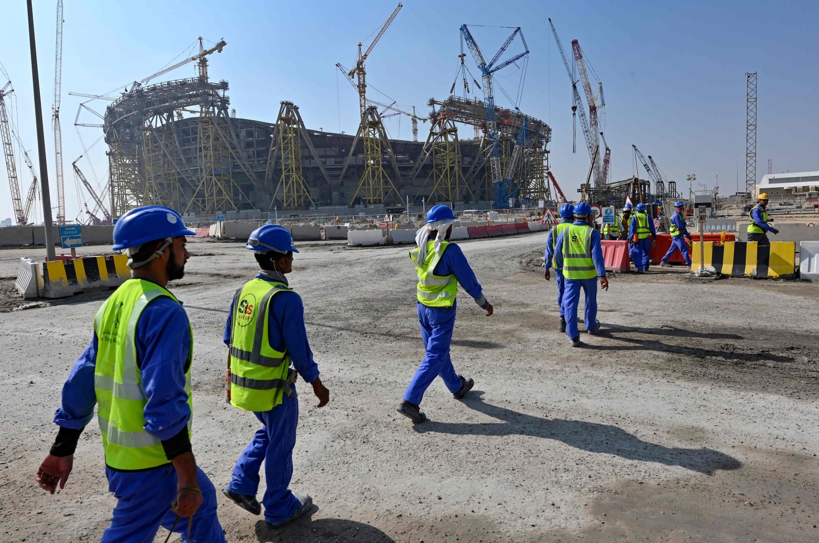 Construction workers walking next to Lusail, one of World Cup stadiums, in Doha, Qatar, Dec. 20, 2019. (AFP PHOTO) 