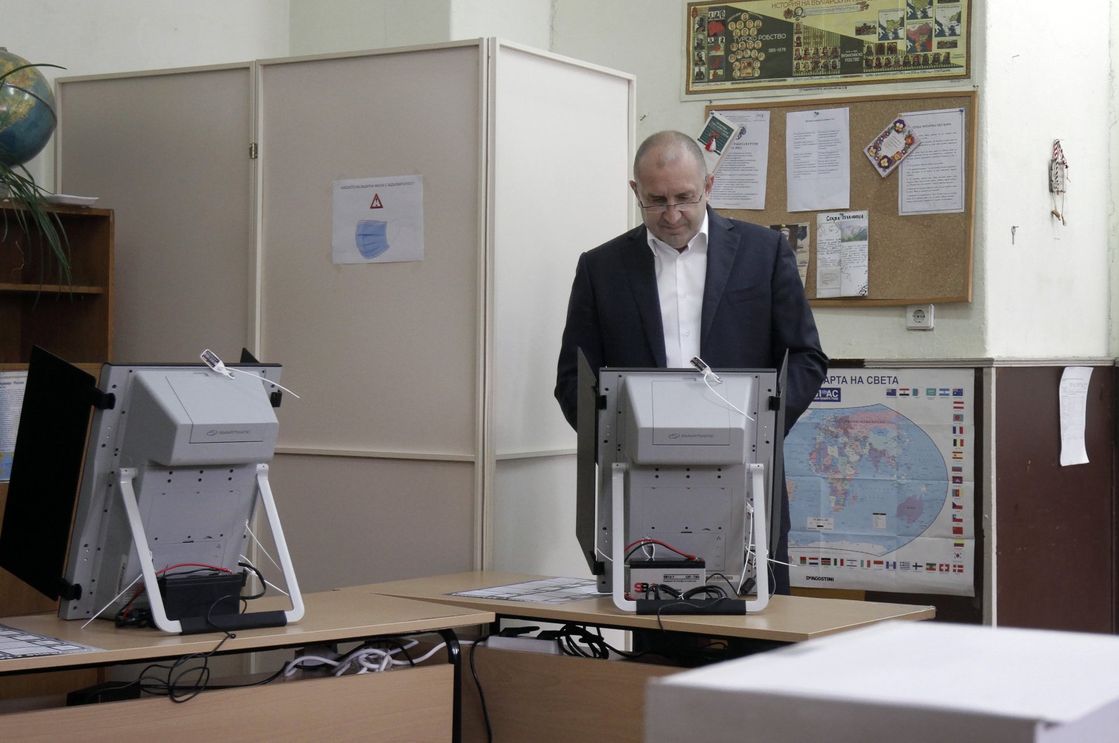 Bulgarian President Rumen Radev votes on a machine at a polling booth in Sofia, Bulgaria, Nov. 21, 2021. (AP Photo)