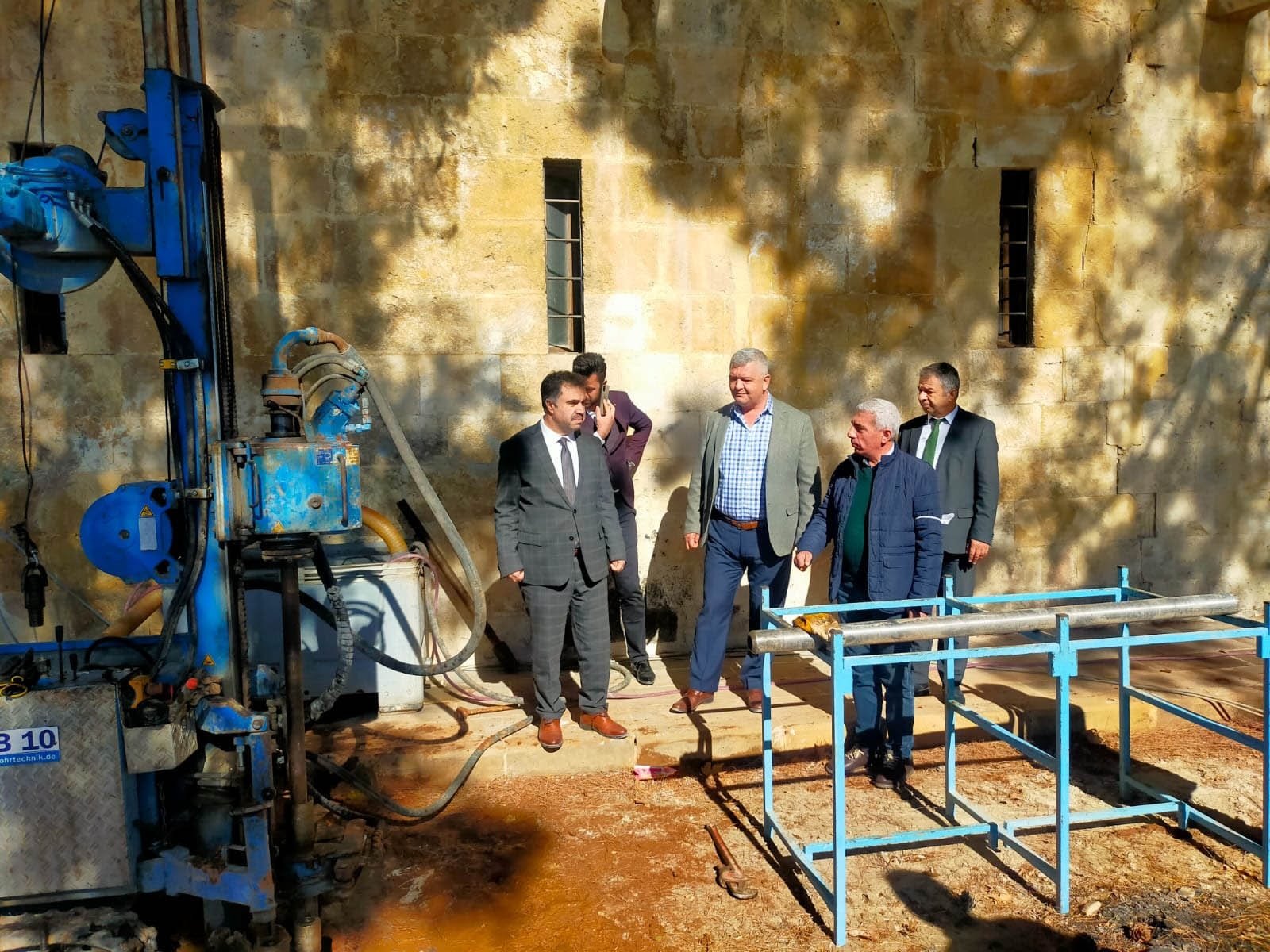 A work machine, worker and officials as restoration works continue at the Tol Madrassa in Ermenek province, Karaman, Turkey, Nov. 16, 2021. (DHA Photo)