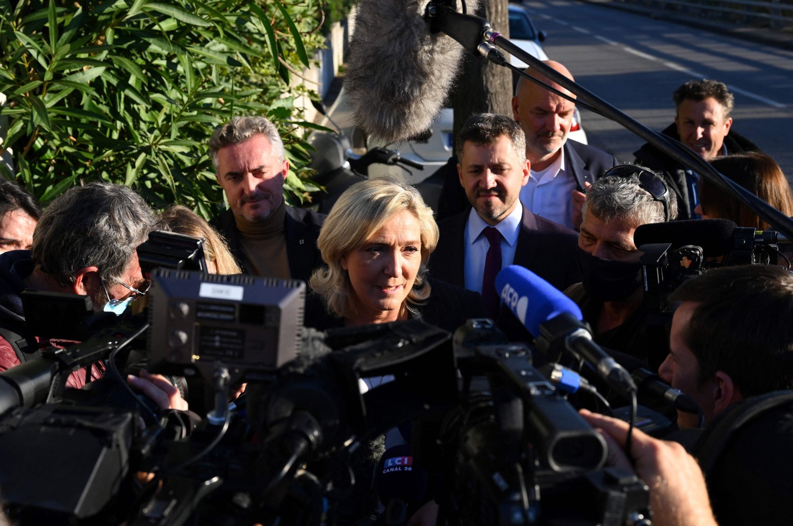 Leader of French far-right party Rassemblement National (RN) and candidate for the 2022 French presidential election Marine Le Pen (C) answers journalists&#039; questions after visiting a police station in the northern neighborhoods of Marseille, France, on Nov. 19, 2021. (AFP Photo)