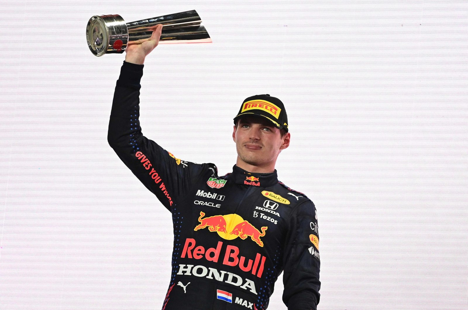 Red Bull&#039;s Dutch driver Max Verstappen raises his 2nd-place trophy on the podium following the Qatari Formula One Grand Prix at the Losail International Circuit, Doha, Qatar, Nov. 21, 2021. (AFP Photo)