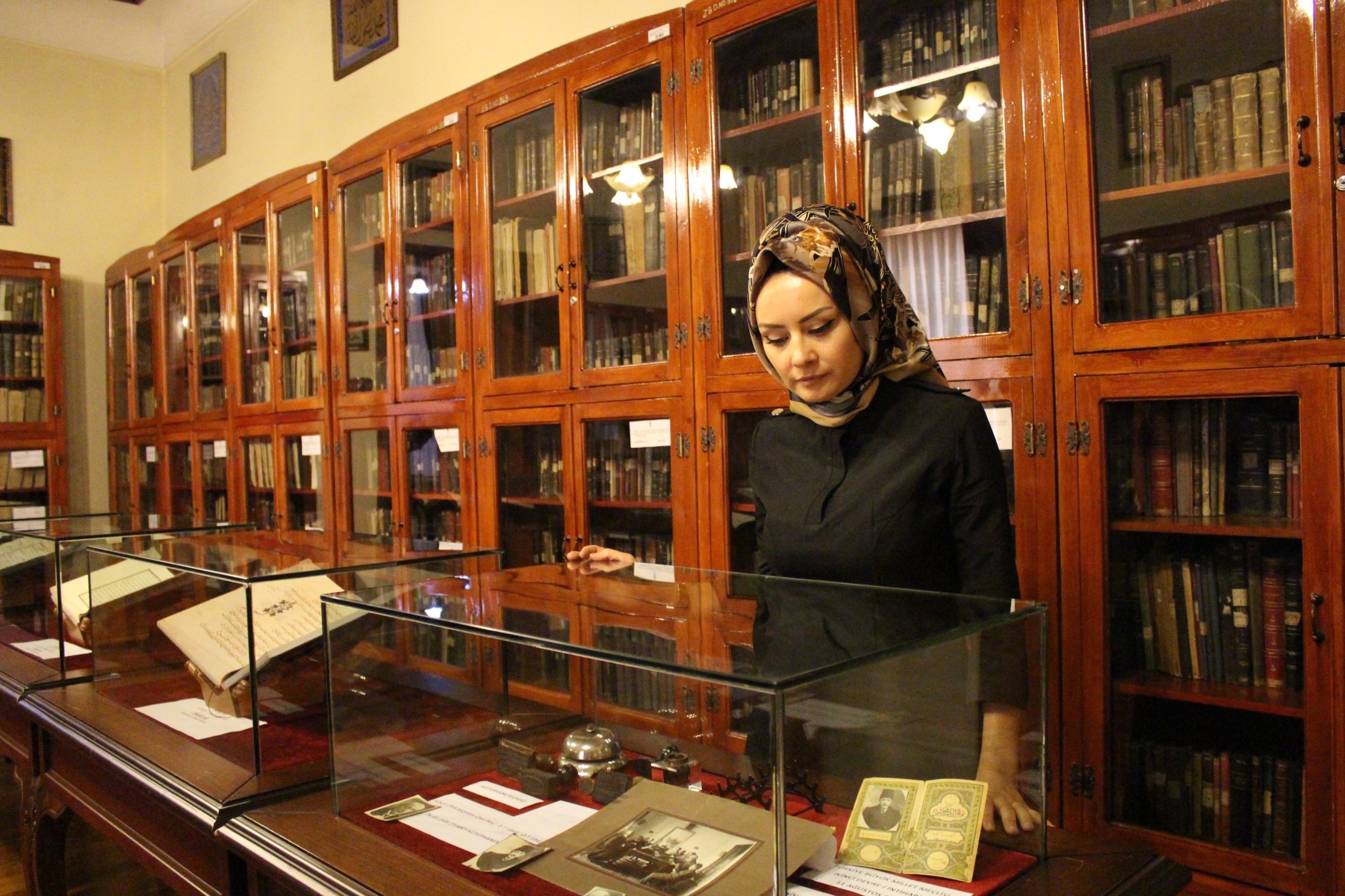 Library Director Dahiye Karagülle is seen together with some works in the historic Ziyabey Manuscripts Library in Sivas, eastern Turkey, Nov. 18, 2021. (IHA Photo)