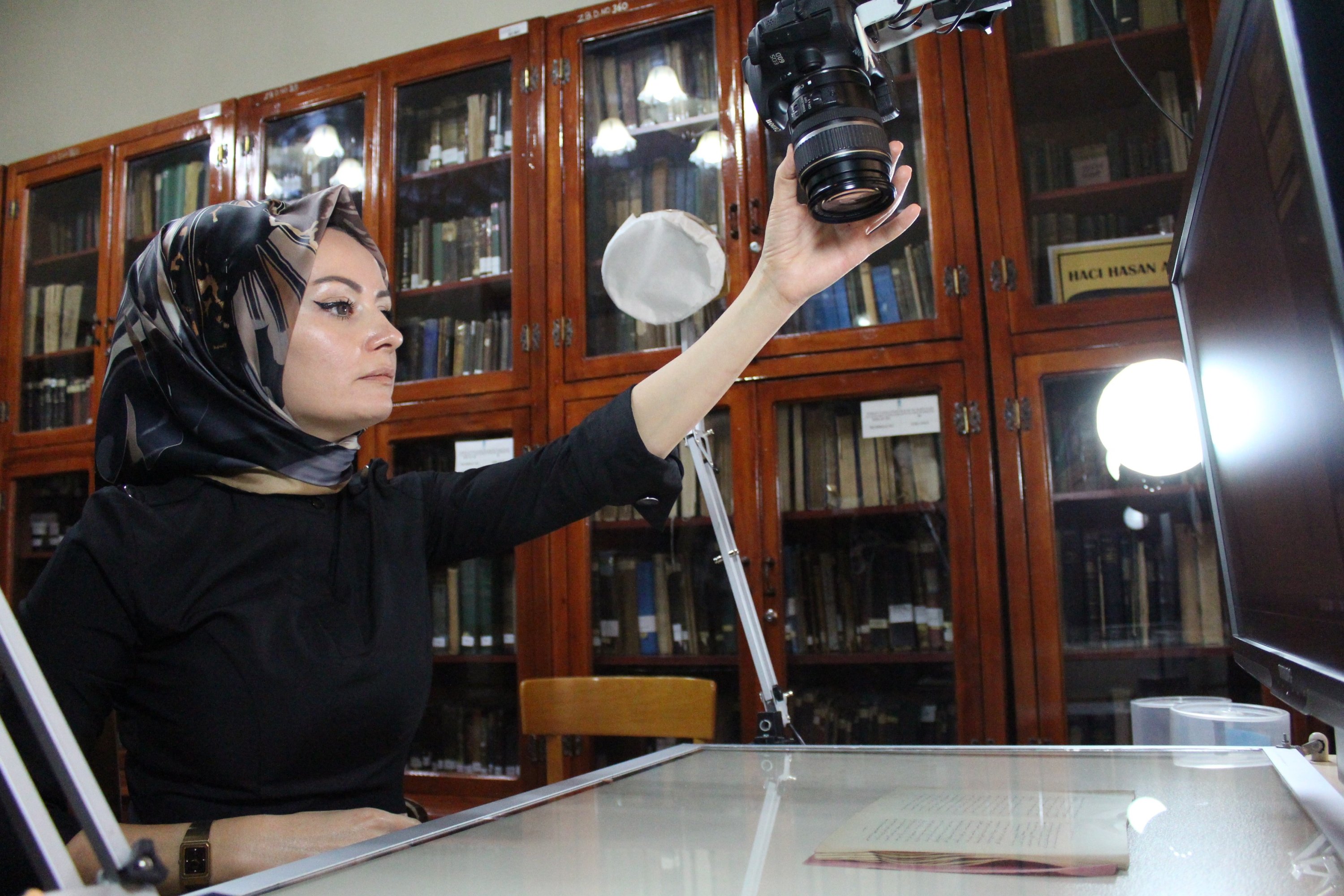 Library Director Dahiye Karagülle is seen together with a manuscript in the historic Ziyabey Manuscripts Library in Sivas, eastern Turkey, Nov. 18, 2021. (IHA Photo)
