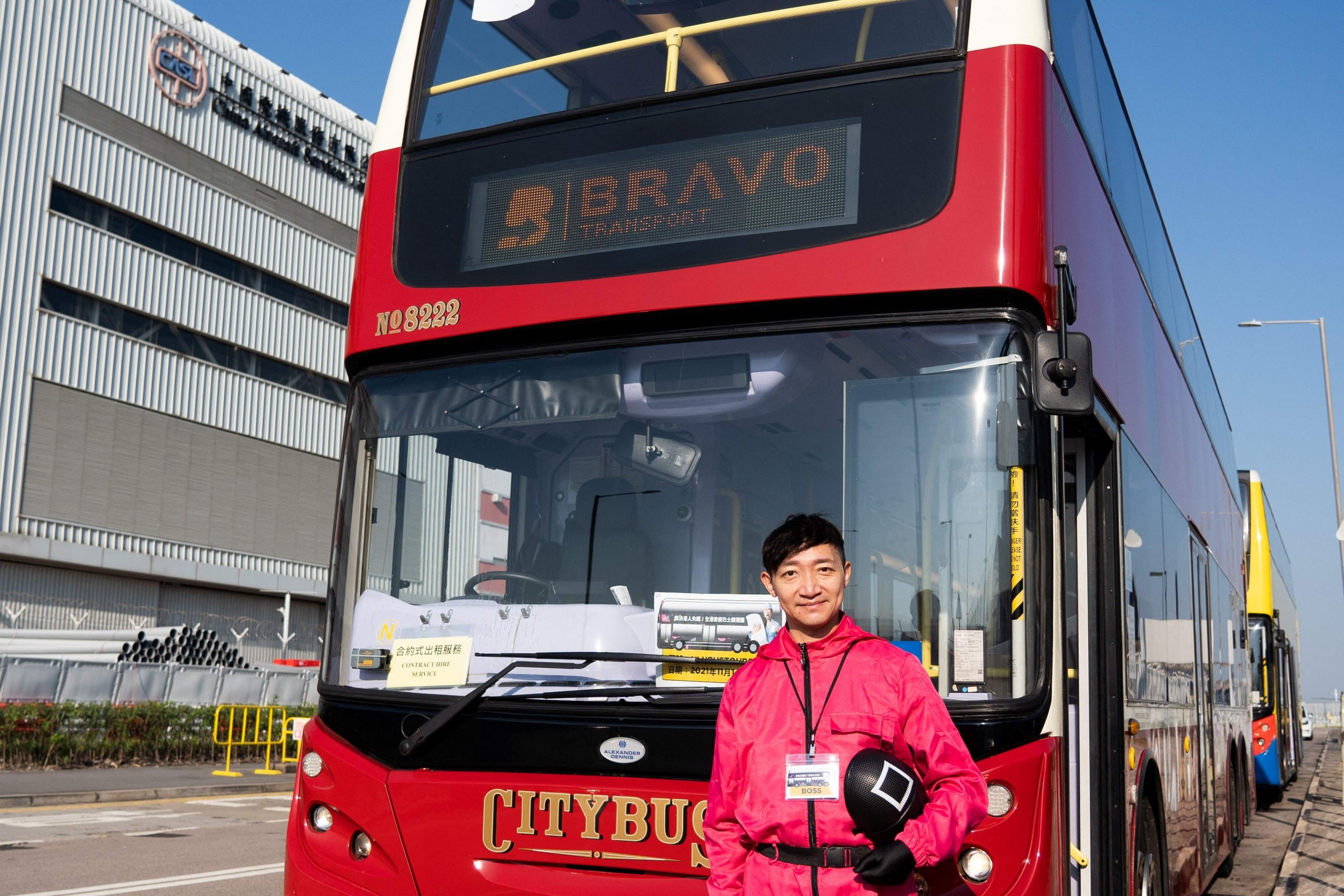 Frankie Chow, president of Ulu Travel, poses in front of one of his buses used for a five-hour "quiet bus" tour marketed as a "route to nowhere" for travel-craving and restless residents to snooze on board in Hong Kong, Nov. 14, 2021. (AFP Photo)