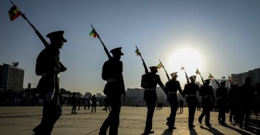 Ethiopian military parade with national flags attached to their rifles at a rally organized by local authorities is held to show support for the Ethiopian National Defense Force (ENDF), at Meskel Square in downtown Addis Ababa, Ethiopia, Nov. 7, 2021. (AP Photo)