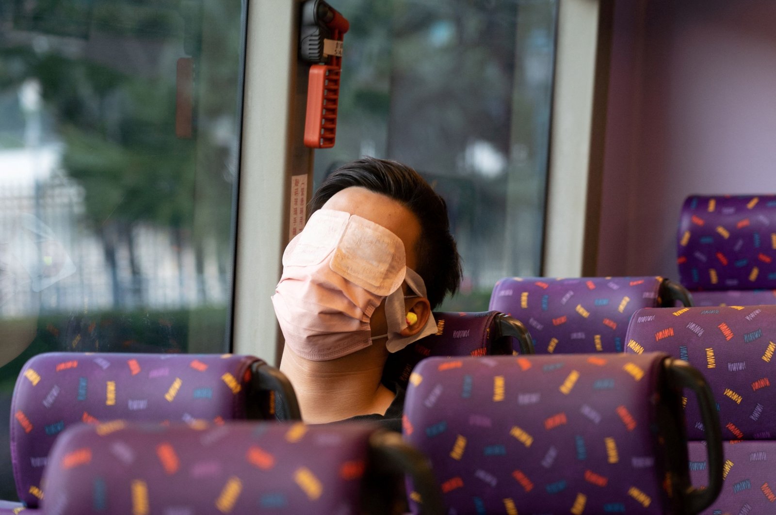 A passenger sleeps on a bus operated by a Hong Kong travel agency offering a five-hour &quot;quiet bus&quot; tour marketed as a &quot;route to nowhere&quot; for travel-craving and restless residents to snooze on board in Hong Kong, Nov. 14, 2021. (AFP Photo)