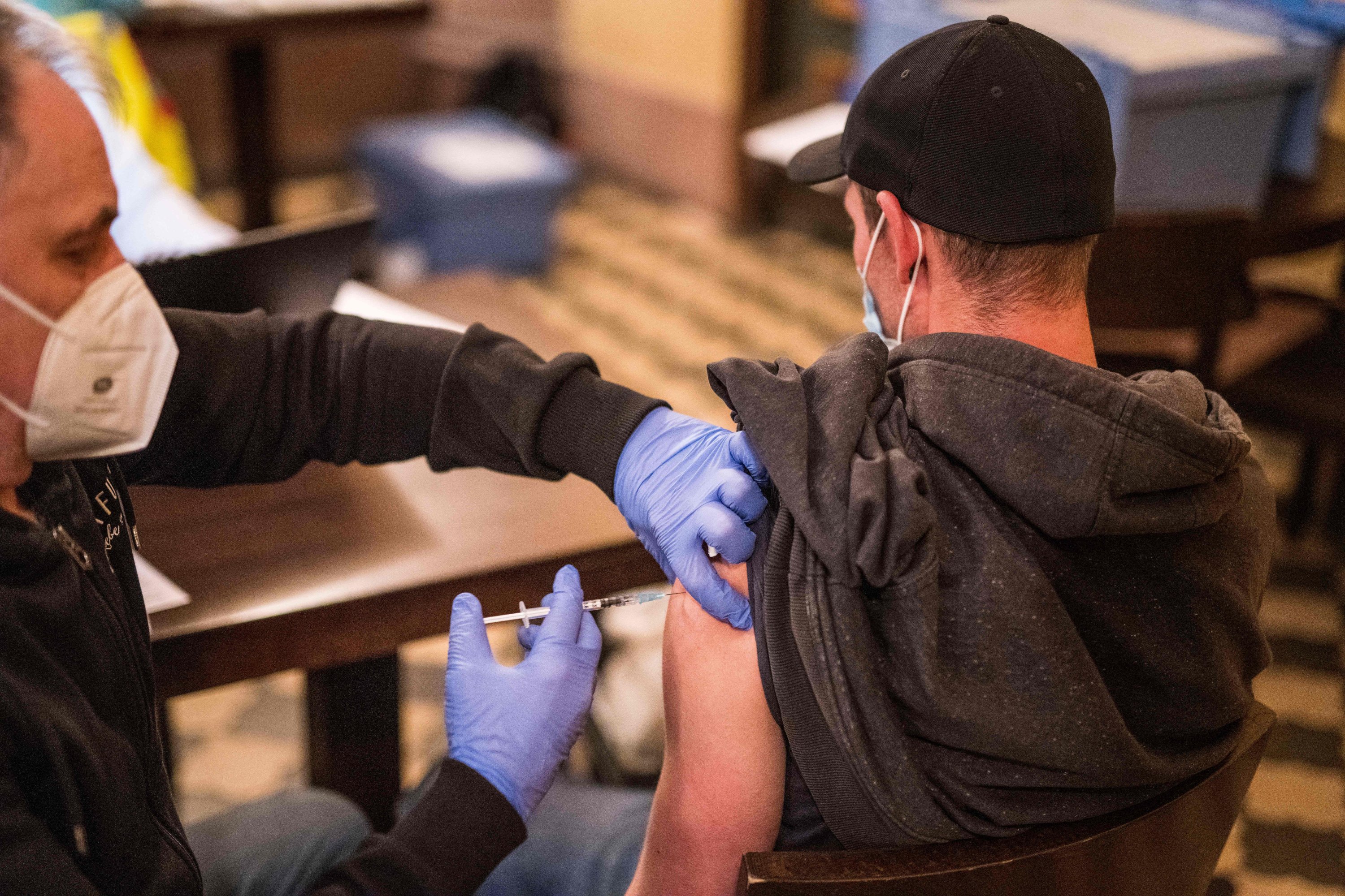 A man receives a vaccination against COVID-19 in Frankfurt am Main on Nov. 23, 2021 during an event where people in need are offered the vaccination and a meal. (AFP Photo)