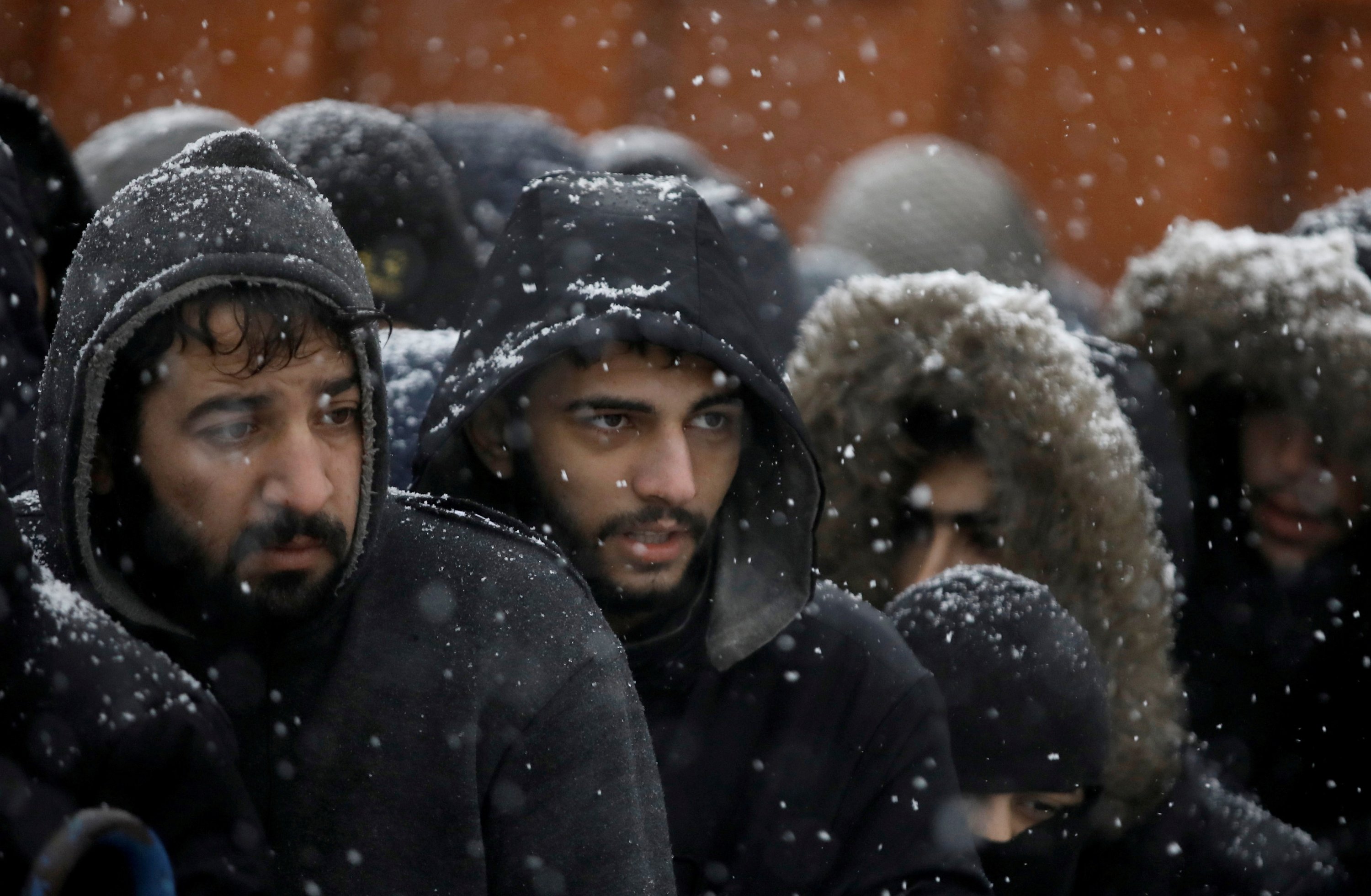 Migrants gather during snowfall at a transport and logistics center near the Belarusian-Polish border in the Grodno region, Belarus, Nov. 23, 2021. (Reuters Photo)