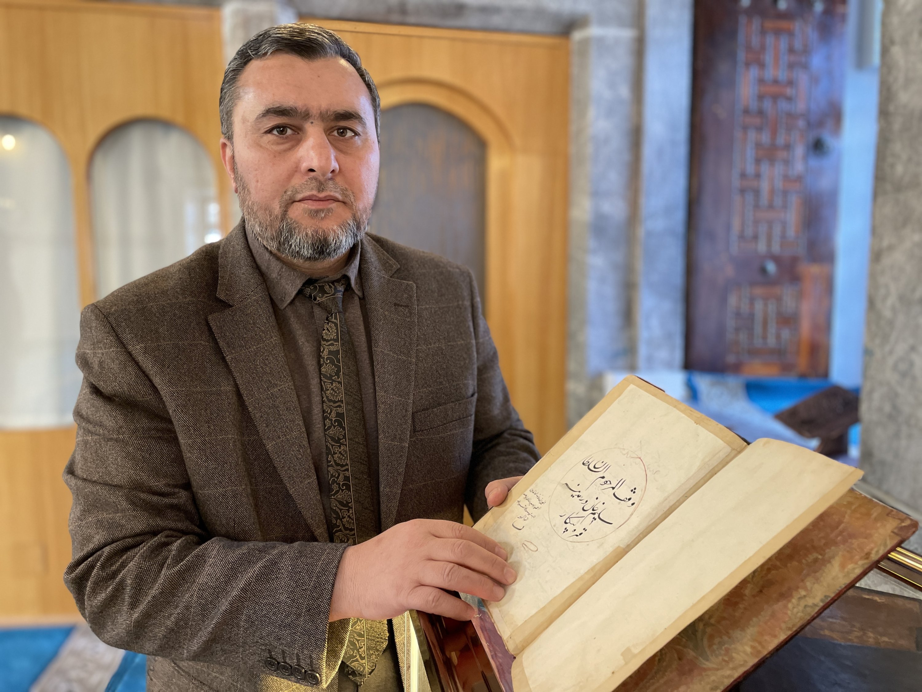 District Mufti Yunus Aydın, with one of the copies of the Quran inside the Sultan Selim Mosque in Konya's Karapınar district, Turkey, Nov. 23, 2021 (AA Photo)