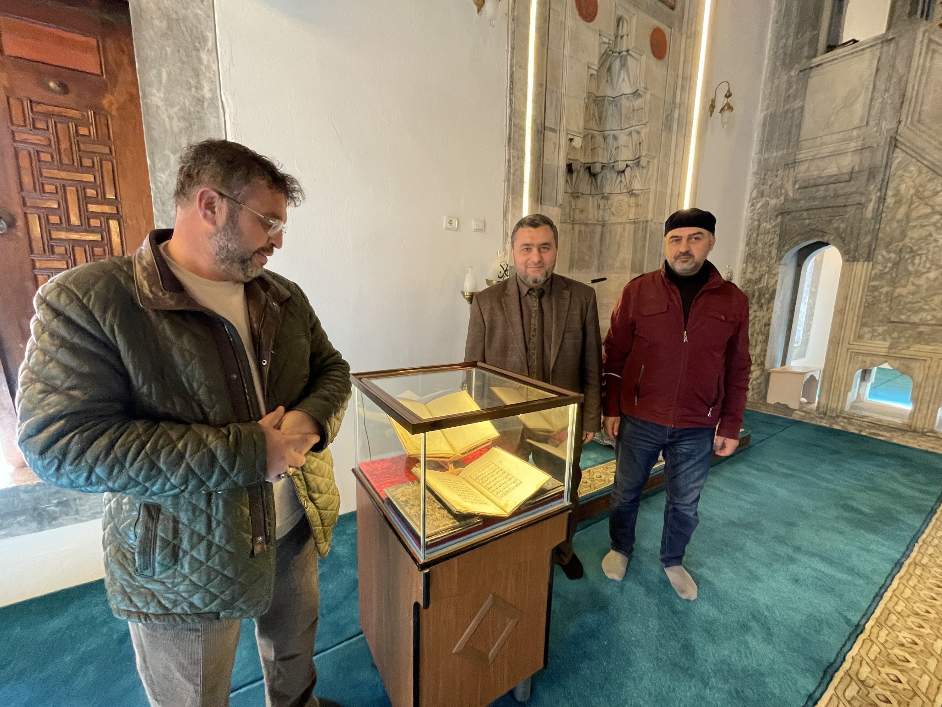 District Mufti Yunus Aydın (C) and colleagues with one of the copies of the Quran displayed inside the Sultan Selim Mosque in Konya's Karapınar district, Turkey, Nov. 23, 2021 (AA Photo)