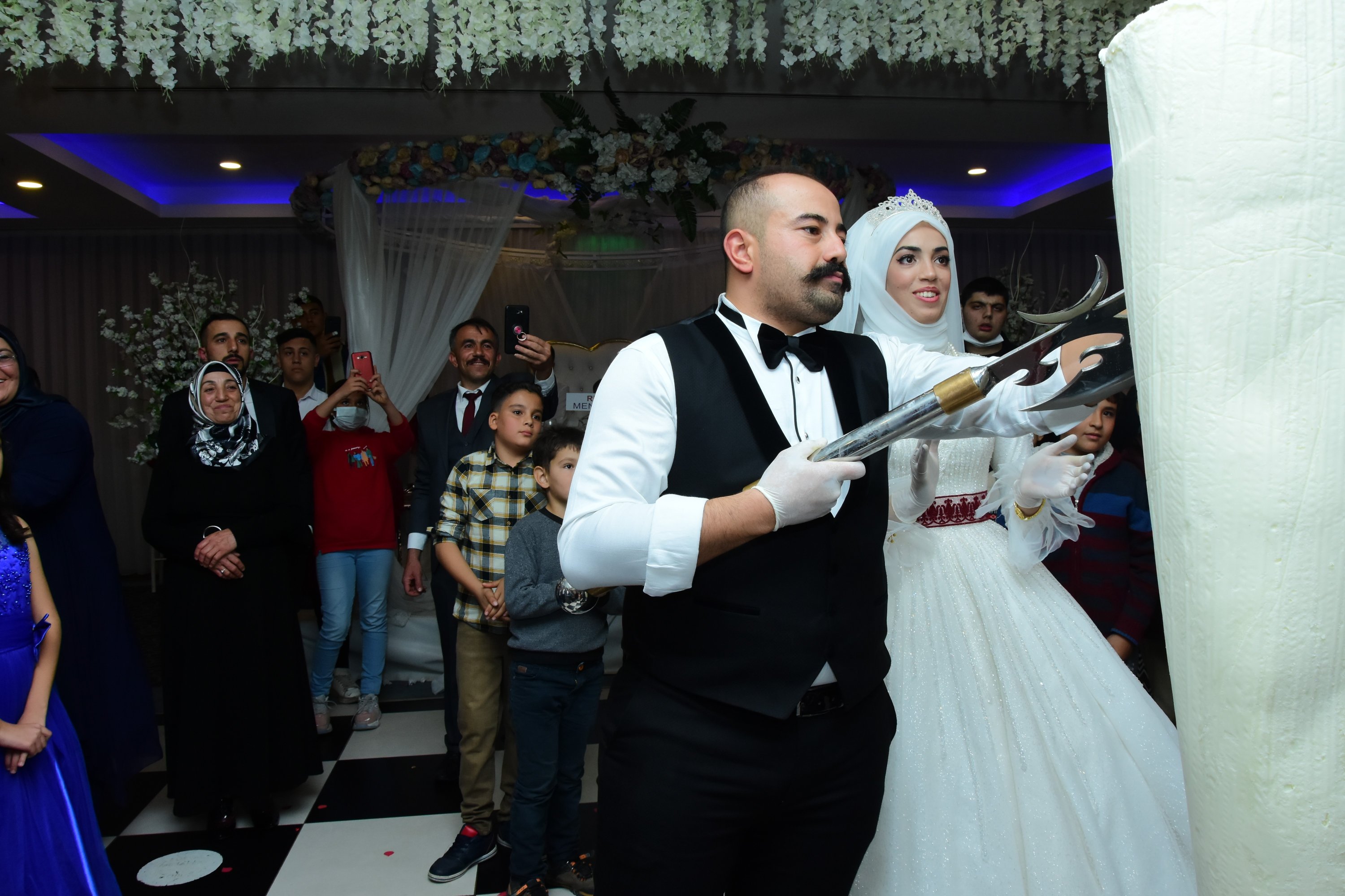 Yakup Ceren with his bride cutting 70 kilograms off a Maraş ice cream slab at his wedding, Kahramanmaraş, Turkey, Nov. 22, 2021. (IHA Photo)