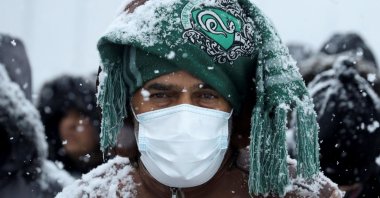 Migrants gather at a transport and logistics center during snowfall, near the Belarusian-Polish border, in the Grodno region, Belarus, Nov. 23, 2021. (Reuters Photo)