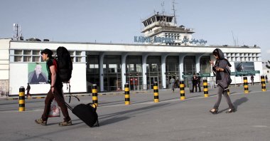 A picture showing passengers passing a portrait of Kabul Hamid Karzai International Airport, in Kabul, Afghanistan, March 26, 2012. (EPA-EFE Photo)