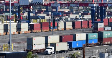 A container truck makes its way past a row of containers stacked at the Port of Long Beach, California, U.S., Nov. 12, 2021. (AFP Photo)