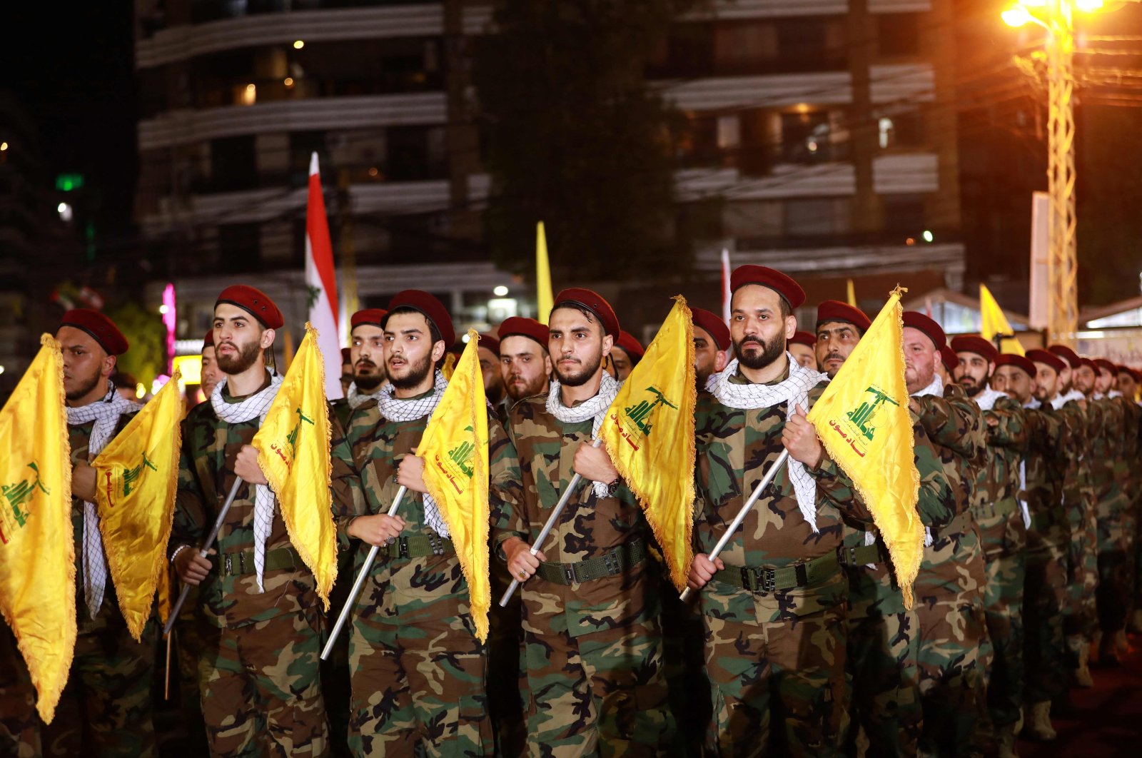 Fighters with the Lebanese Shiite Hezbollah party carry flags as they parade in a southern suburb of the capital Beirut to mark the al-Quds International Day, May 31, 2019. (AFP Photo)