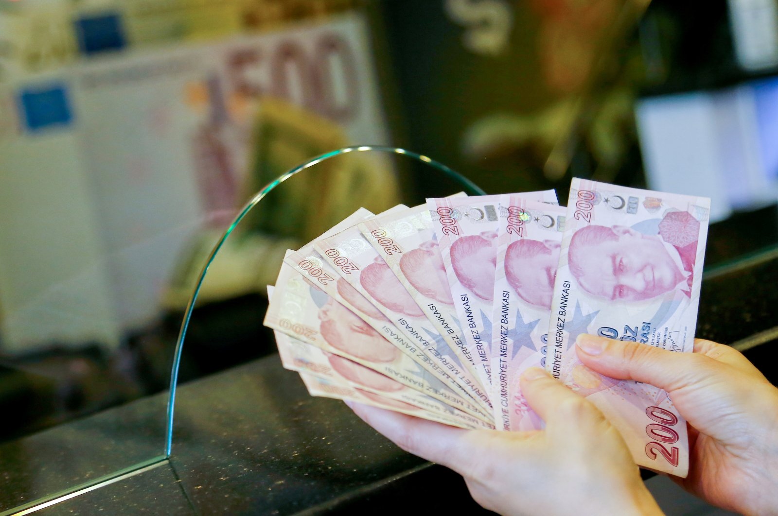 A money changer holds Turkish lira banknotes at a currency exchange office in Ankara, Turkey, Sept. 27, 2021. (Reuters Photo)