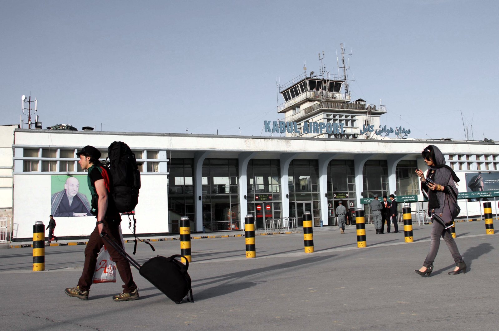 A picture showing passengers passing a portrait of Kabul Hamid Karzai International Airport, in Kabul, Afghanistan, March 26, 2012. (EPA-EFE Photo)