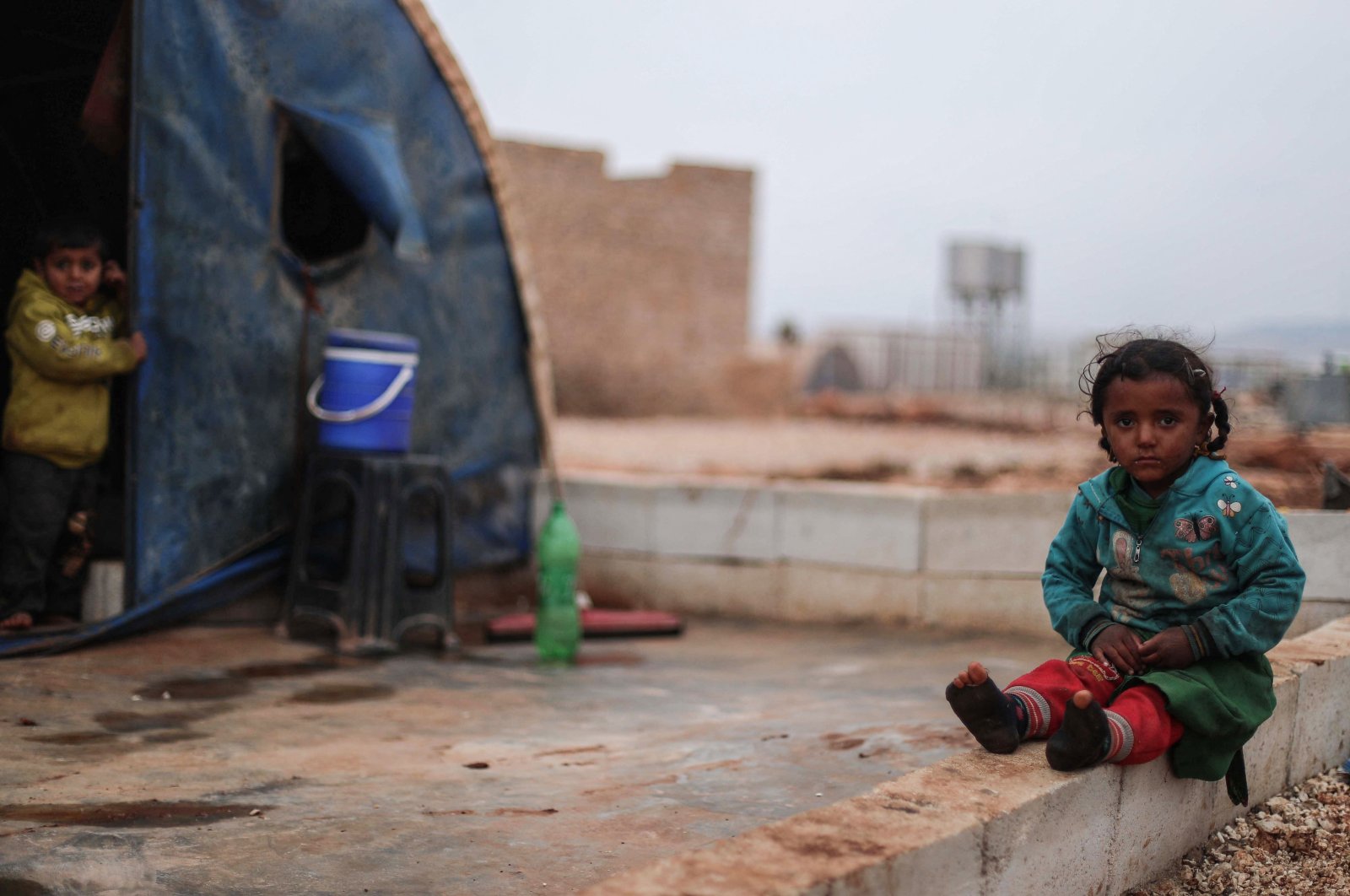 A child on sits in front of a tent at the Bardaqli camp for displaced people in the town of Dana in northwestern Idlib province, Syria, Nov. 20, 2021. (AFP Photo)