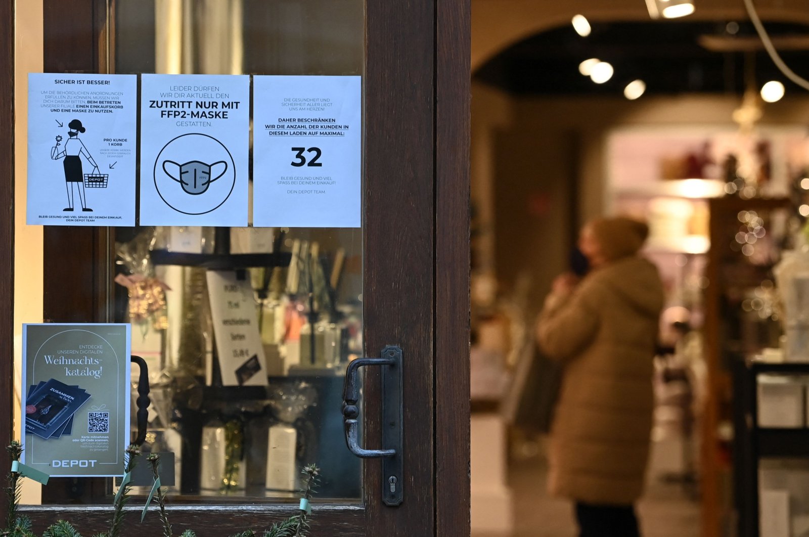 Amid the ongoing COVID-19 pandemic, information posters are seen at the entrance of a store in Muehldorf am Inn, southern Germany, Nov. 24, 2021 (AFP Photo)