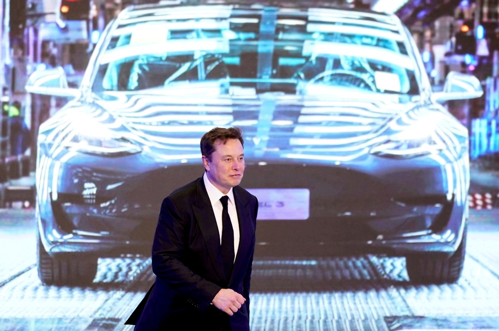 Tesla Inc CEO Elon Musk walks next to a screen showing an image of Tesla Model 3 car during an opening ceremony for Tesla China-made Model Y program in Shanghai, China, Jan. 7, 2020. (Reuters Photo)