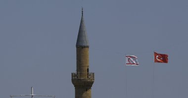 The flags of Turkey and the TRNC flutter by the minaret of the Hagia Sofia with the flags of Greece and Greek Cyprus on poles below, in the divided capital Lefkoşa, TRNC, April 26, 2021. (AP File Photo)