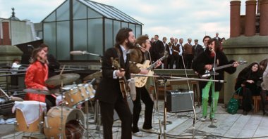 Ringo Starr (L), Paul McCartney (C-L), John Lennon (C-R) and George Harrison, with Yoko Ono, seated on the right, in a scene from the nearly 8-hour Peter Jackson-produced documentary “Get Back.” (Disney  via AP)