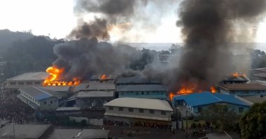 This screengrab taken and received on Nov. 25, 2021, from a video from ZFM Radio shows parts of the Chinatown district on fire in Honiara on Solomon Islands, as rioters torched buildings in the capital in the second day of anti-government protests, Solomon Islands. (JOB RONGO'AU FUOO / ZFM Radio / AFP)