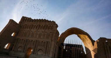 Birds fly over scaffolding at the Arch of Ctesiphon, also known as Taq Kisra (Khosrow's Arch), at the ancient site of Ctesiphon near al-Madain, central Iraq, Nov. 24, 2021. (AFP Photo)