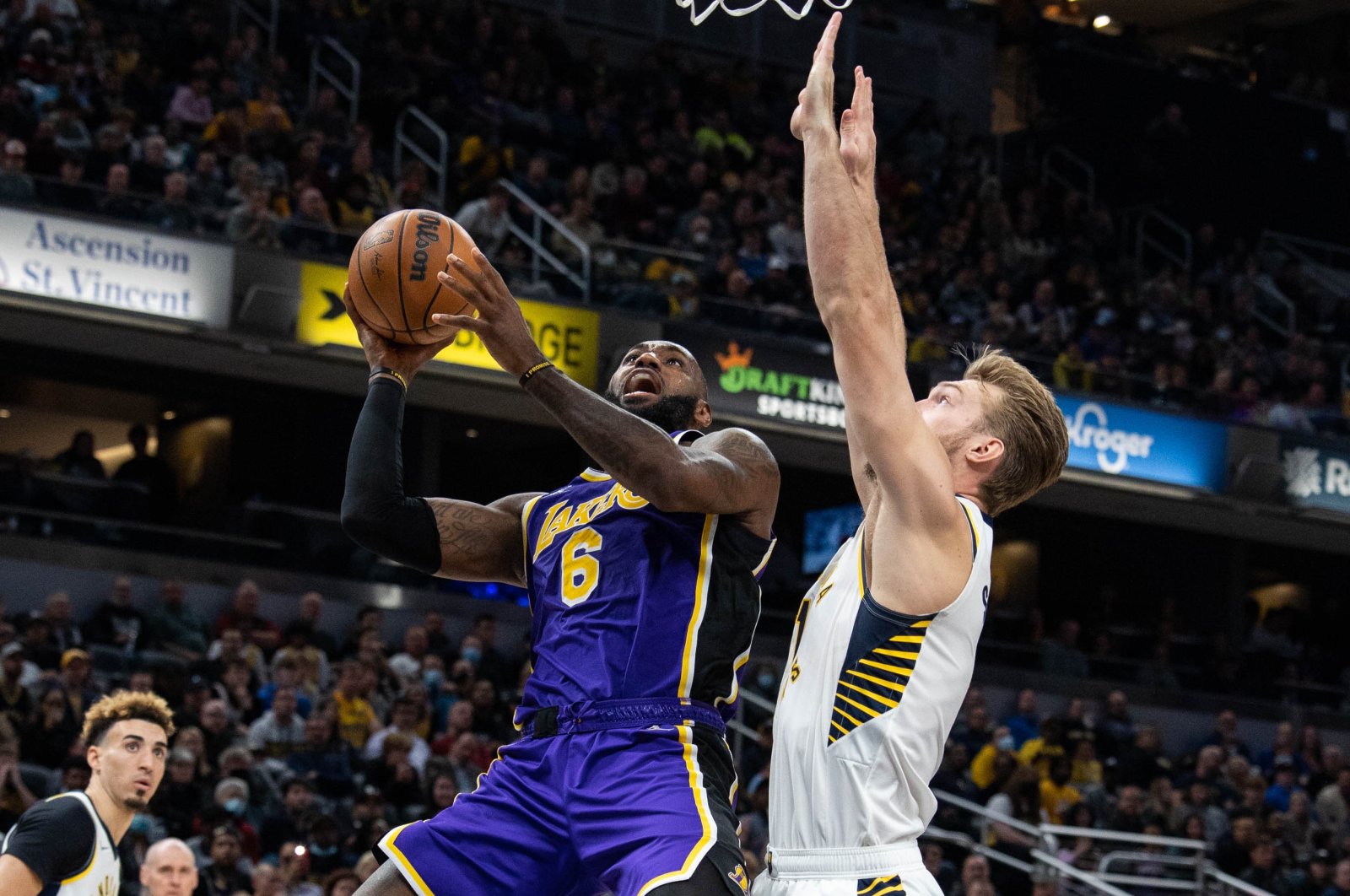 LA Lakers forward LeBron James (L) shoots the ball past Indiana Pacers forward Domantas Sabonis during an NBA game at Indianapolis, Indiana, U.S., Nov 24, 2021. (Reuters Photo)