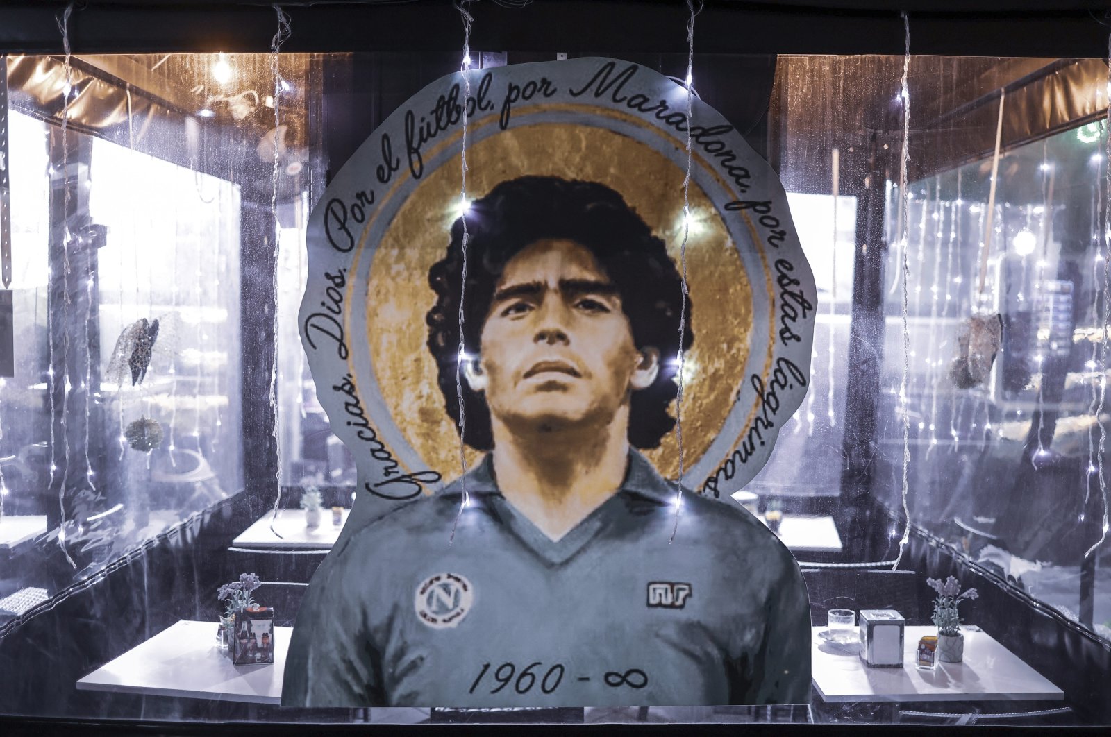 A portrait of Diego Armando Maradona stands out at a restaurant in Naples, Italy, Nov. 24, 2021. (AP Photo)