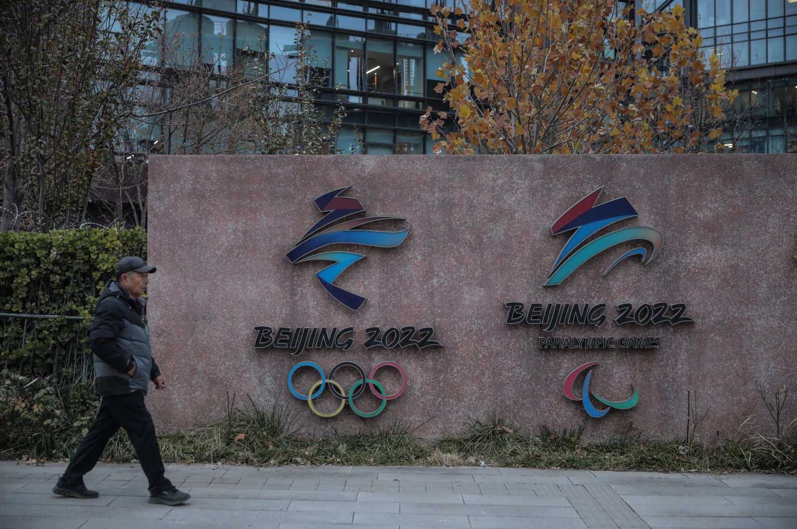 People walk past logos of the 2022 Beijing Winter Olympics at Shougang Park, Beijing, China, Nov. 19, 2021. (EPA Photo)