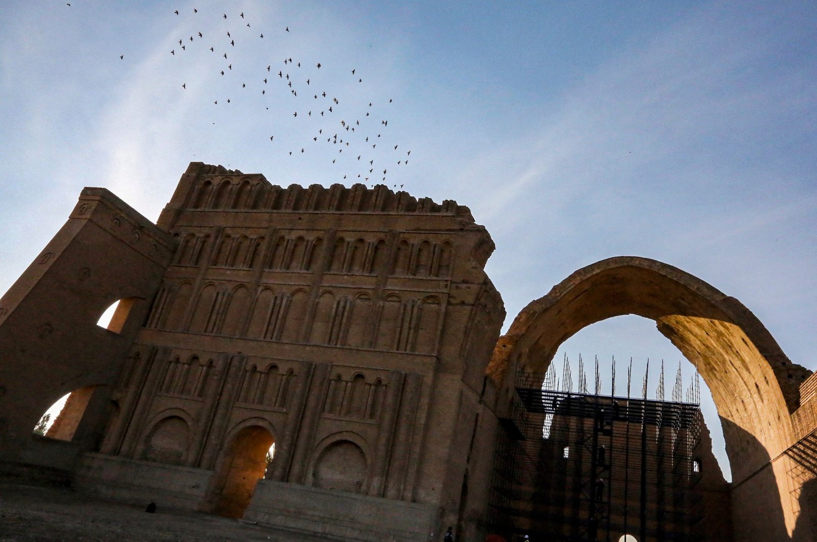 Birds fly over scaffolding at the Arch of Ctesiphon, also known as Taq Kisra (Khosrow&#039;s Arch), at the ancient site of Ctesiphon near al-Madain, central Iraq, Nov. 24, 2021. (AFP Photo)