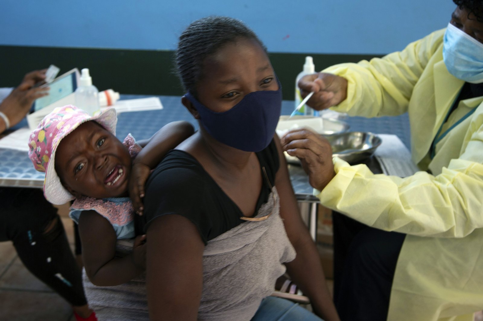 A baby cries as her mother receives her Pfizer vaccine against COVID-19, in Diepsloot Township near Johannesburg, Oct. 21, 2021. (AP File Photo)